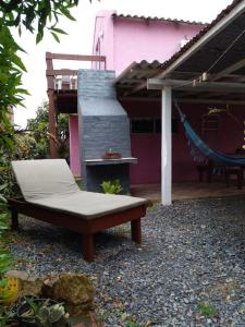 un banco sentado frente a una casa rosa en Cabañas Punta Palmar (Casa 3) en Punta del Diablo