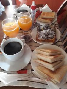 a table topped with plates of breakfast foods and coffee at Cabañas Punta Palmar (Casa 3) in Punta Del Diablo