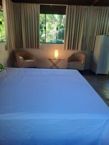 a large white bed in a room with a window at venha curtir a natureza in Nova Friburgo