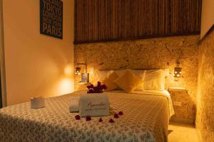 ein Hotelzimmer mit einem Bett mit einem Blumenstrauß darauf in der Unterkunft BUGANVILIA in Paracas