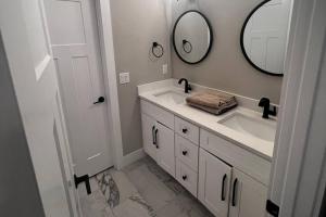 a white bathroom with a sink and a mirror at 7 Min from Broadway! 3 Bed 2.5 Bath (Sleeps 10+) in Nashville