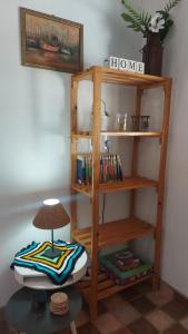 a wooden book shelf with a lamp on a table at Recanto Águas Claras in Soledade de Minas