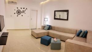 sala de estar con sofá y TV en Byblos Deluxe, en Áqaba