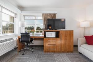 a hotel room with a desk with a television and a couch at Marshall Suites in Bainbridge