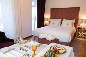 a hotel room with a bed and a table with food at Hotel República Boutique Hotel in Tomar