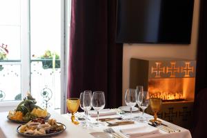 uma mesa de jantar com copos de vinho e uma lareira em Hotel República Boutique Hotel em Tomar
