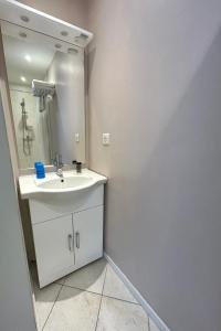 uma casa de banho branca com um lavatório e um espelho em Les Voyageurs em Charols