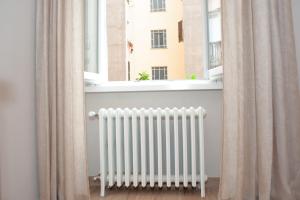 a radiator in front of a window with curtains at SCIPIO92HOME in Rome