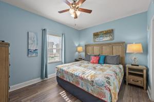 a bedroom with a bed and a ceiling fan at White Sandy Beaches, Sunsets & Seashells at Laketown Wharf #402 by Nautical Properties in Panama City Beach