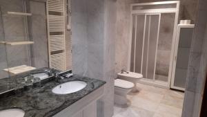 a bathroom with a sink and a toilet at Pension Grilo in Padrón