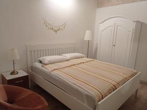 a white bedroom with a bed and a chair at LUNA in Monopoli