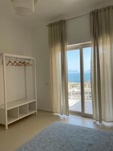 a bedroom with a large window with a view of the ocean at Casa Langellotti plus in Naples