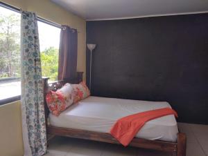 een bed in een kamer met een raam en een bed sidx sidx sidx bij House la Rose Second Floor in Manuel Antonio