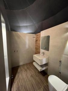 La salle de bains est pourvue d'un lavabo blanc et de toilettes. dans l'établissement شاليه سدرة فاطمه, à Banī Ma‘n