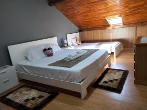 1 dormitorio con 2 camas y 2 alfombras en Casa da Emilia do Gerês en Outeiro
