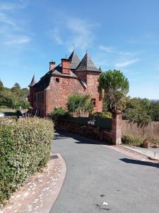 科隆熱的住宿－Château de Vassinhac chambres d'hôtes Collonges la rouge，街道上一座带屋顶的大型砖砌建筑