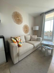 - un salon avec un canapé blanc et une table dans l'établissement Appartement vue sur l'océan, à La Parée Preneau