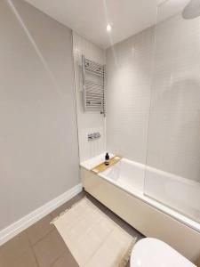 a white bathroom with a tub and a toilet at City Apartment with Terrace in Leicester