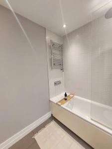 a white bathroom with a tub and a shower at City Apartment with Terrace in Leicester