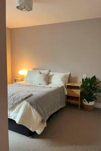 a bedroom with a bed and a table with a plant at City Apartment with Terrace in Leicester