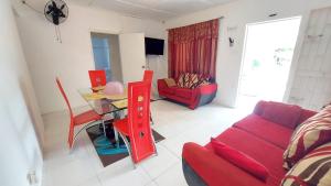 ein Wohnzimmer mit einem roten Sofa und einem Tisch in der Unterkunft Lovely 2 Bedroom House in St Thomas Jamaica in Belfast