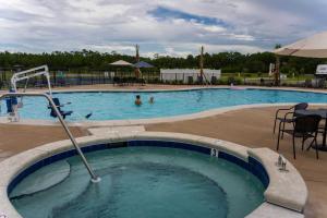 ein Pool in einem Resort mit Menschen, die darin schwimmen in der Unterkunft Gulf Shores RV Resort in Gulf Shores