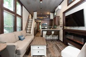 a living room with a couch and a tv in a tiny house at Gulf Shores RV Resort in Gulf Shores
