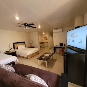 a living room with two beds and a flat screen tv at Hotel CH in Guadalupe