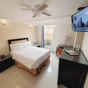 a bedroom with a bed and a flat screen tv at Hotel CH in Guadalupe