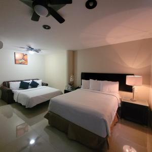 une chambre d'hôtel avec deux lits et une lampe dans l'établissement Hotel CH, à Guadalupe