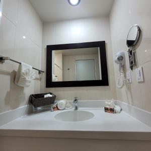 La salle de bains est pourvue d'un lavabo et d'un miroir. dans l'établissement Hotel CH, à Guadalupe