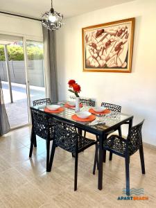 comedor con mesa negra y sillas en APARTBEACH GREEN RELAX MUY LUMINOSO JUNTO PLAYA y BARBACOA, en Salou