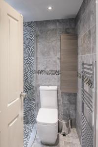 a bathroom with a white toilet in a room at The Brixton Apartment in London