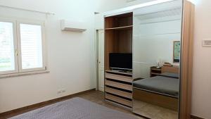 モンデッロにあるVilla Ginevraのベッドルーム(鏡、ベッド、テレビ付)