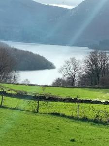 un campo verde con vistas al lago en Casa da Emilia do Gerês en Outeiro