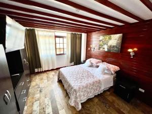 a bedroom with a bed in a room with wooden walls at Casa Villa Victoria en Pisco in Pisco