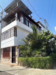 una casa blanca con una palmera delante de ella en Casa Villa Victoria en Pisco, en Pisco