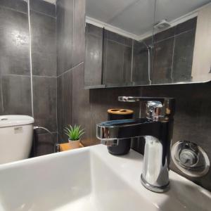 bagno con lavandino e rubinetto di R&T Apartments a Kallithea