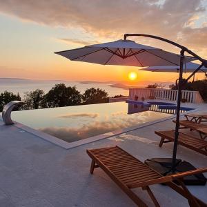 un parasol et un banc à côté de la piscine dans l'établissement Sea view Luxury Hotel Villa Conte with private swiming pool and romantic SPA, à Podstrana