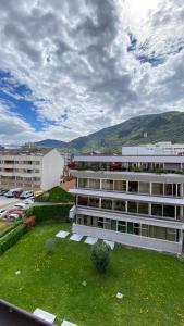 a large white building with a green lawn in front of it at Life Studio & City Bike in Bolzano