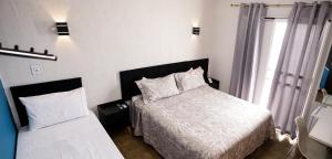 a small bedroom with a bed and a window at Hotel Recanto do Sossego in Uberlândia