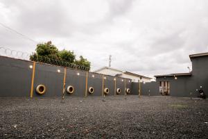 a chain link fence with yellow posts in a parking lot at Hotel Recanto do Sossego in Uberlândia