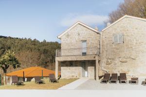 a stone house with a table and chairs at Quinta do Rabelo in Braga