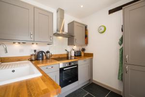 kuchnia z białymi szafkami i zlewem w obiekcie Lena Cottage at Wringworthy Farm on Dartmoor National Park, close to Tavistock, ideal base for exploring Devon and Cornwall, hiking, horse riding, golf, fuelled by green energy w mieście Marytavy