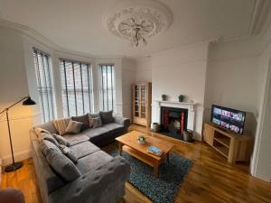 a living room with a couch and a fireplace at Modern Luxury 3 bed house in Plymouth