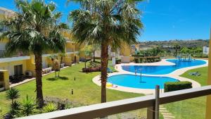 een resort met een zwembad en palmbomen bij Splendide Appartement Standing Casa Biblos en Famille ou en Amoureux in Albufeira
