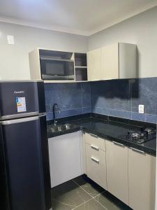 a kitchen with a sink and a microwave at Apartamento Alto Padrão - Com Ar in Campina Grande