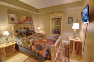 ein Schlafzimmer mit einem Bett, zwei Lampen und einem Fenster in der Unterkunft Tenderfoot Lodge 2613 in Keystone