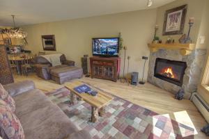 ein Wohnzimmer mit einem Sofa und einem Kamin in der Unterkunft Tenderfoot Lodge 2613 in Keystone