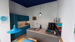 a kitchen with blue cabinets and a blue ceiling at Designerwohnung Berlin Mitte in Berlin